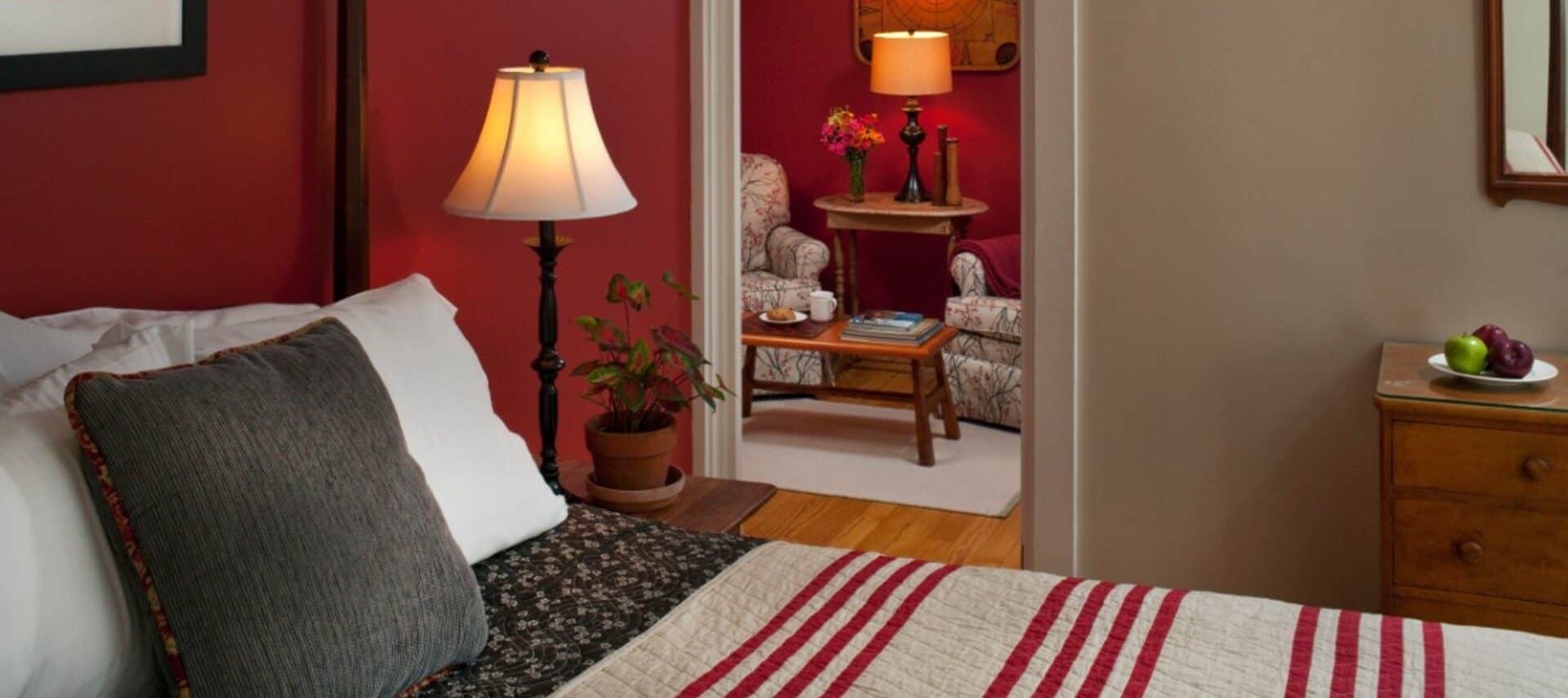 guest room with burgandy walls and striped comfortor