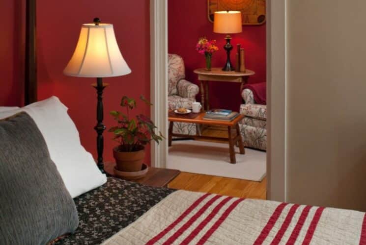 guest room with burgandy walls and striped comfortor