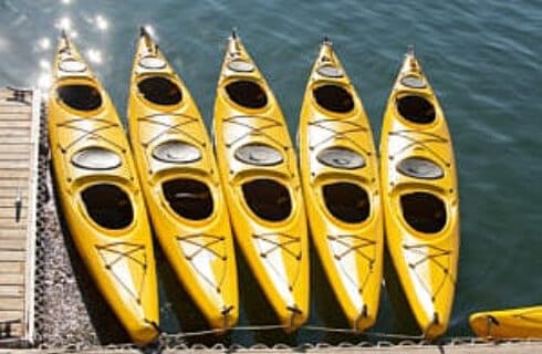 Five yellow kayaks lined up at the dock.