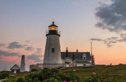 White lighthouse against the sunset sky in Maine