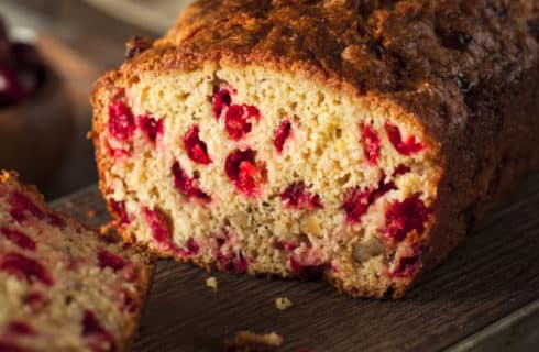 Cranberry quick bread cut open to show red berried studding the bread.