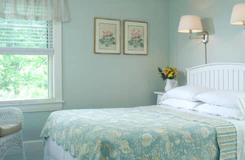 Bright and airy bedroom with pale aqua walls and bedding on the queen-sized bed.