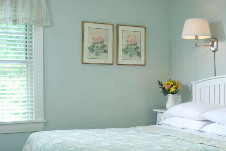 Bright and airy bedroom with pale aqua walls and bedding on the queen-sized bed.