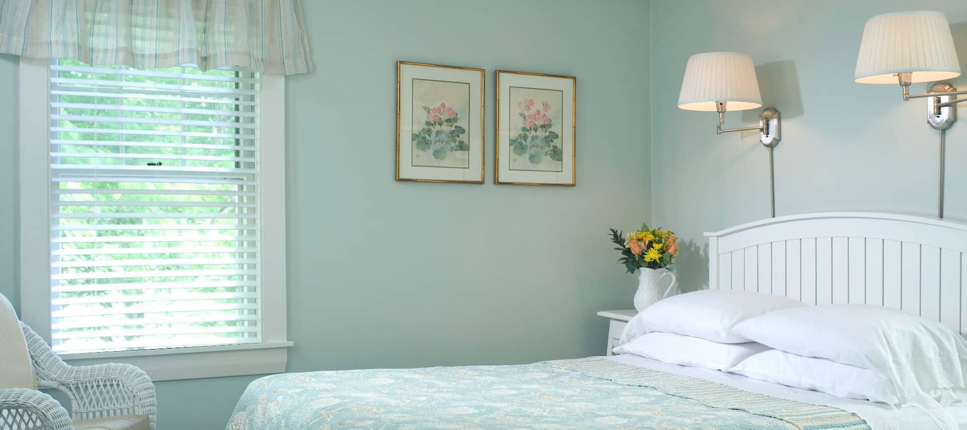 Bright and airy bedroom with pale aqua walls and bedding on the queen-sized bed.