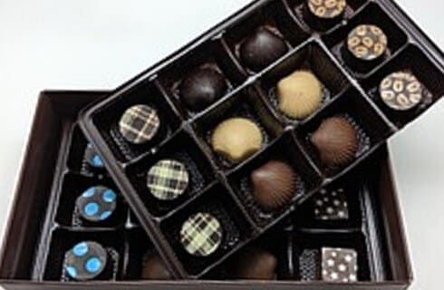 Chocolates of all kinds lined up in double tiered box with rows and columns.